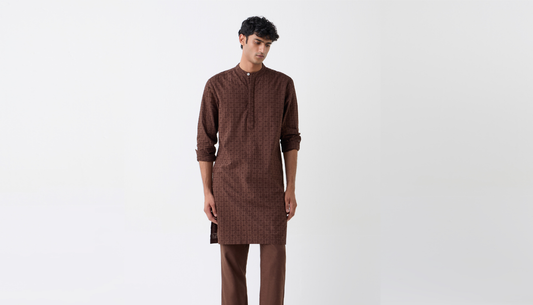 Man styled in festive wedding outfit wearing kurta and jacket at an Indian wedding